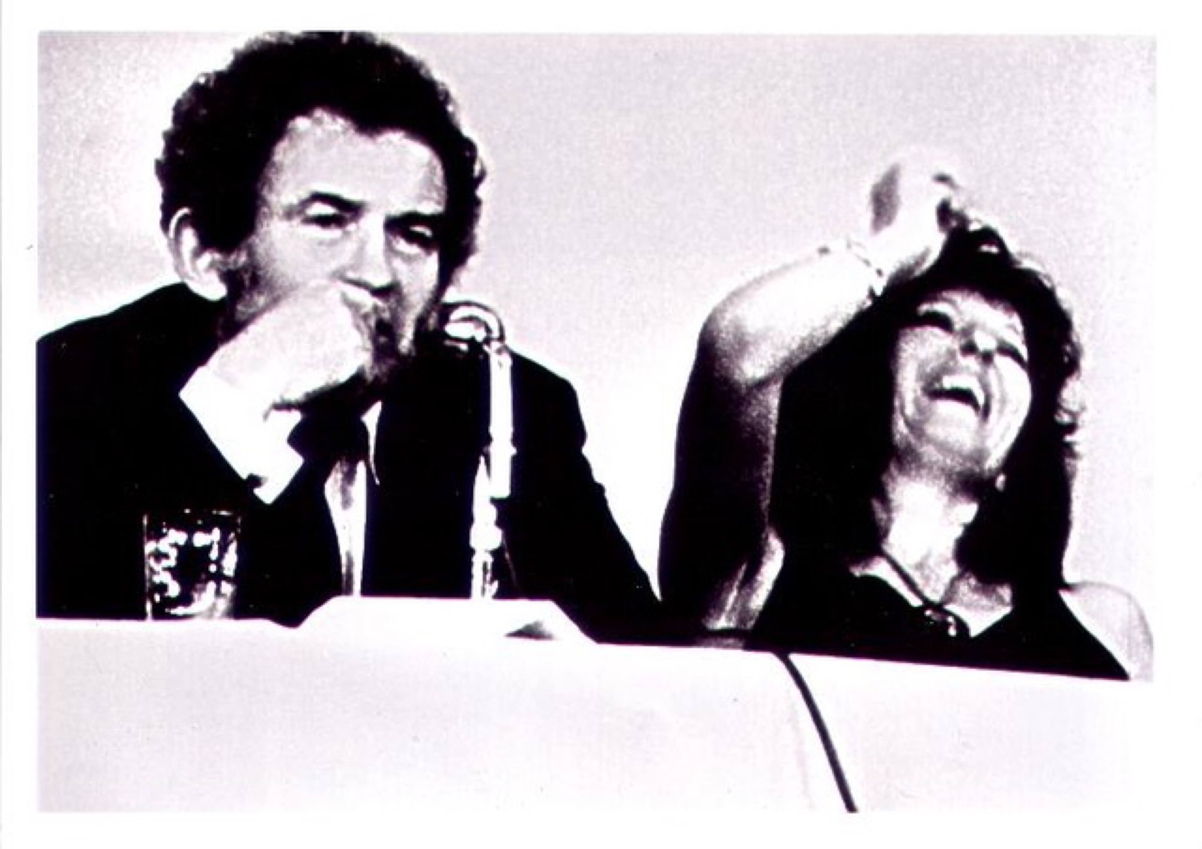 Filmstill in schwarz-weiß: Town Bloody Hell, 1979, Mann und Frau rauchen und lachen