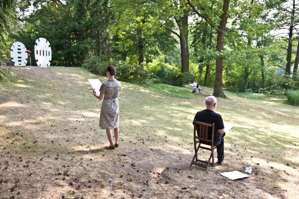 Zwei Personen, die in einem Garten zeichnen.