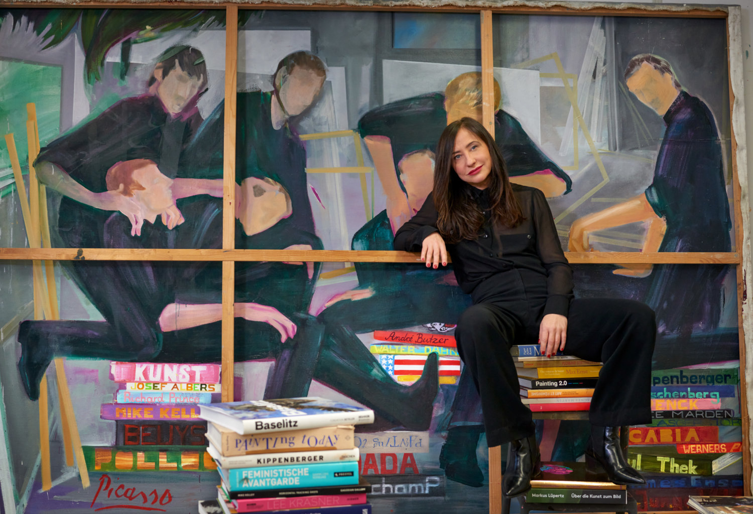 Die Malerin Egle Otto in ihrem Studio auf Kunstkatalogen sitzend