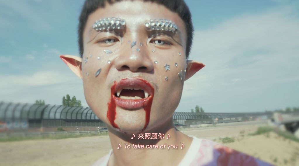 Eine Art futuristischer Vampir-Mensch schaut in die Camera. Still einer Videoarbeit von Yong Xiang Li. 