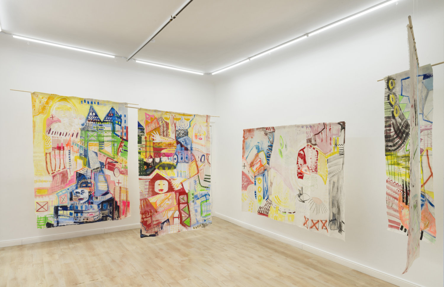 Ausstellungsansicht mit Arbeiten von Stella Meris in der Galerie Anahita Contemporary, zu sehen sind bunt bemalte Stoffe, die im weißen Raum hängen
