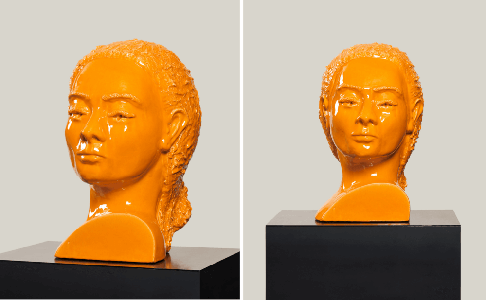 Zwei orange-farbene Frauenköpfe aus Keramik