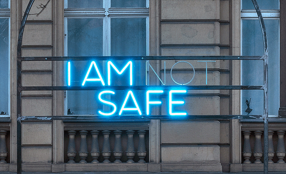 Der blaue Neon-Schriftzug "I AM NOT SAFE" an der Fassade der PSM Gallery. Das "not" blinkt.
