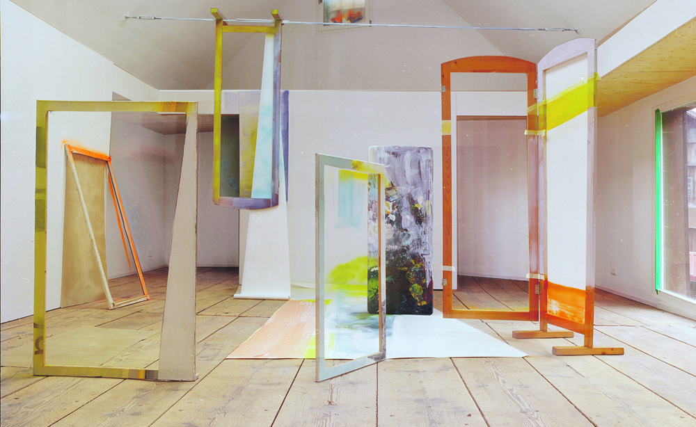 Atelieransicht von Heike Gallmeier, zu sehen ist eine große Rauminstallation mit verschiedenfarbigen Rahmen, die verschieden angeordnet sind