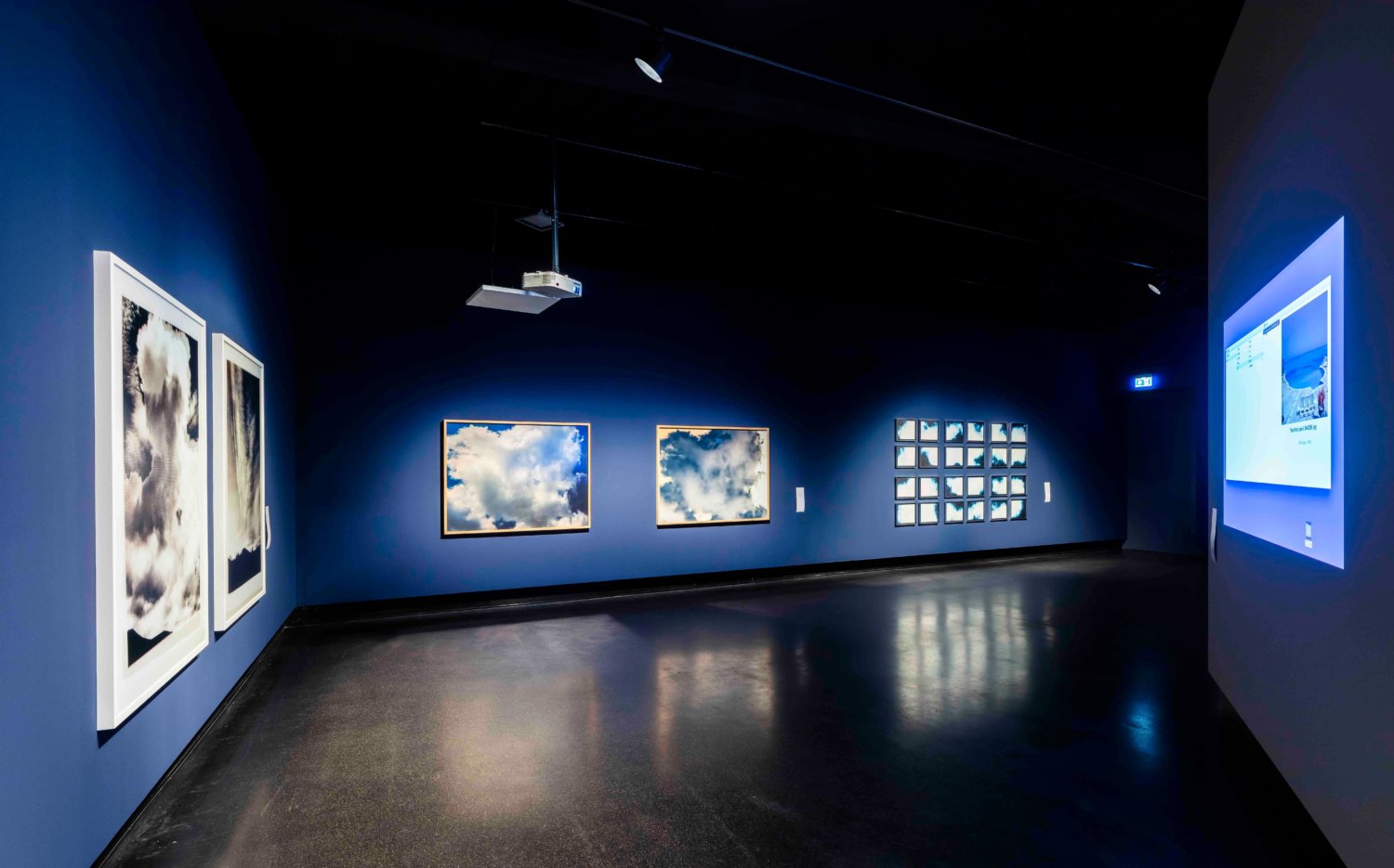 Ausstellungsansicht mit verschiedenen Wolkenmotiven und Blautönen