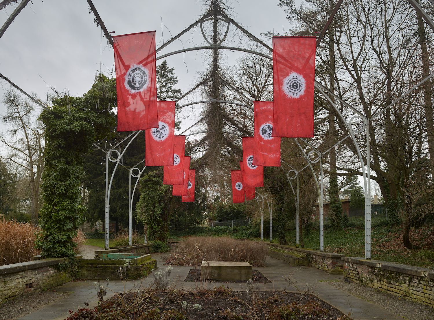 Hinter dem Neuen Aachener Kunstverein sind von der Frankfurter Hauptschule entlang der Allee rote Flagen mit schwarz-weißen Symbolen installiert.