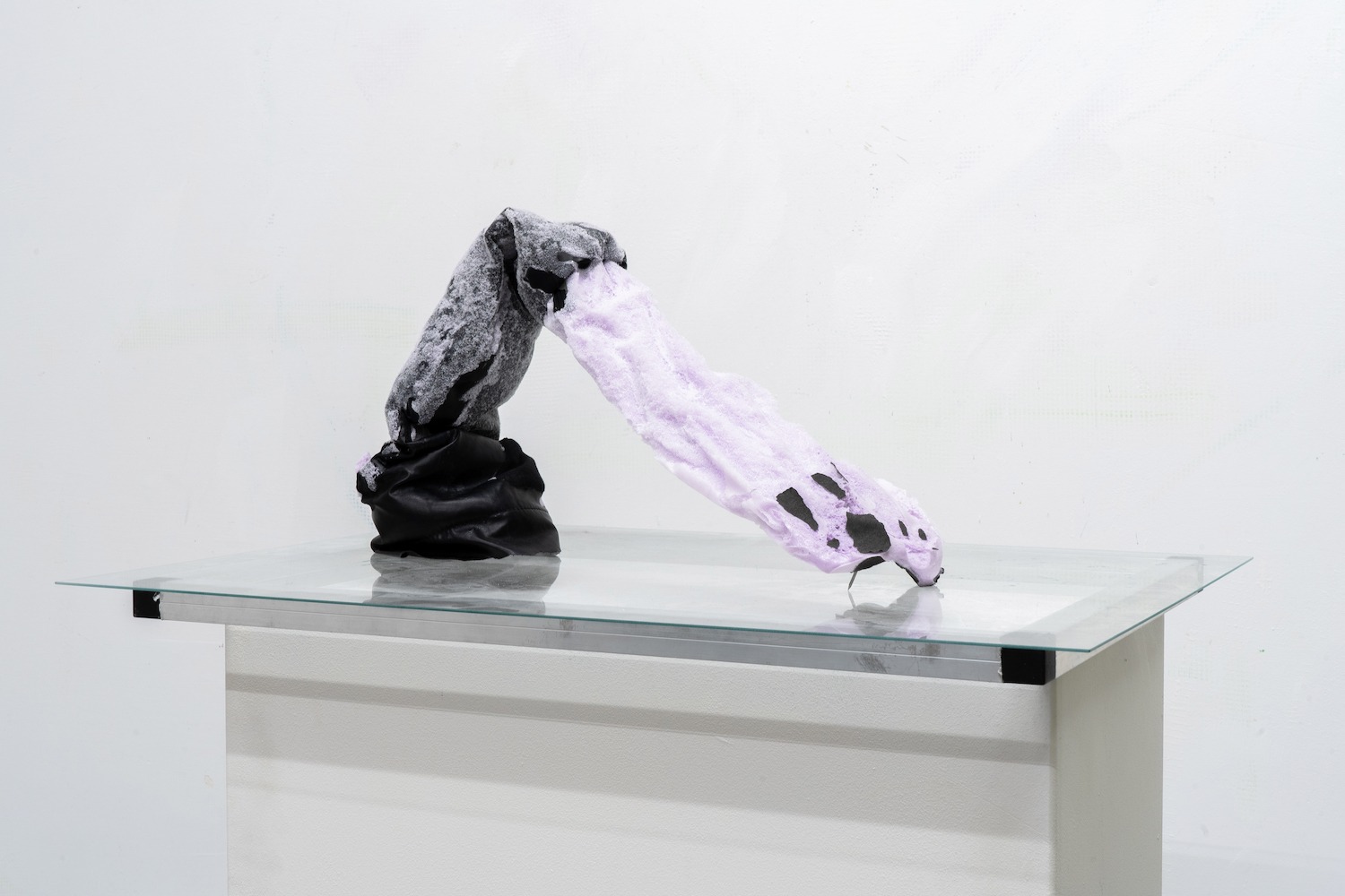 Ein futuristisches Gebilde in Schwarz und Violet auf einer Glasplatte.