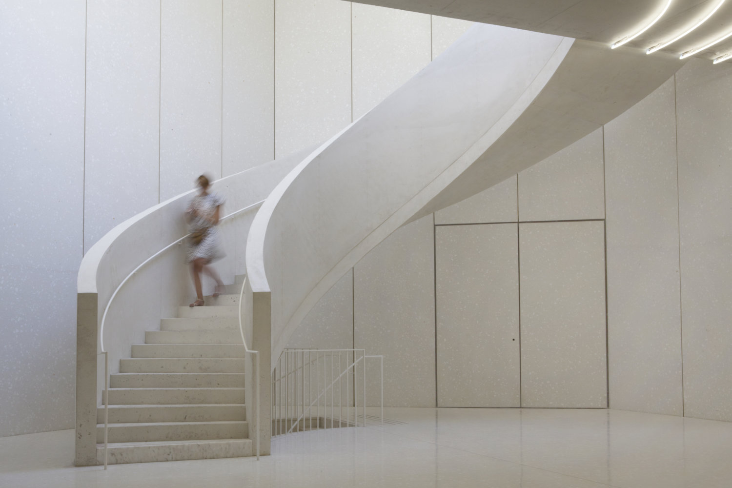 Eine Treppe in einem weiß gehaltenen Gebäude.