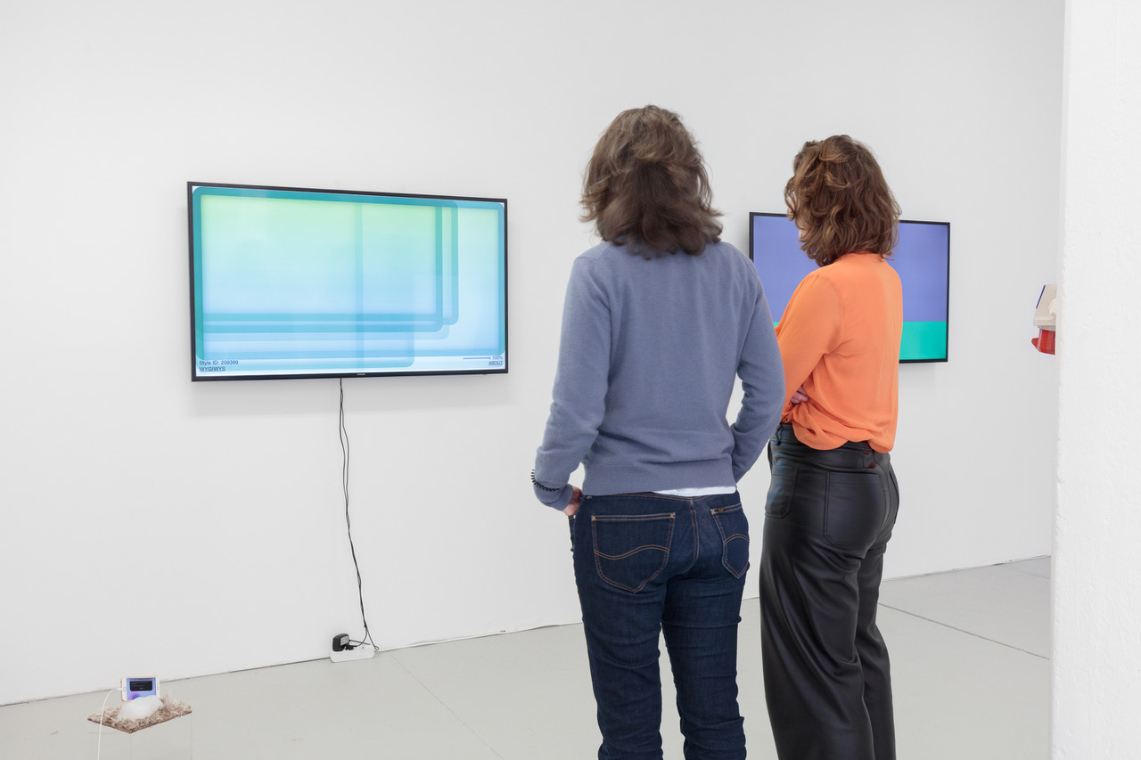 Die Galeristinnen Anne Schwanz und Johanna Neuschäffer betrachten NFTs auf Screens in ihrer Galerie Office Impart.2