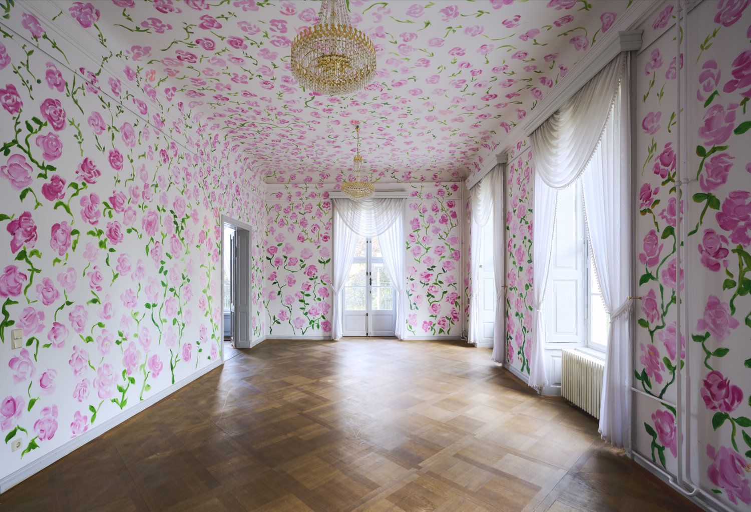 Ein leerer Raum eines Schlosses ist komplett mit Rosen bemalt, die sich über Wände und Decke ziehen.