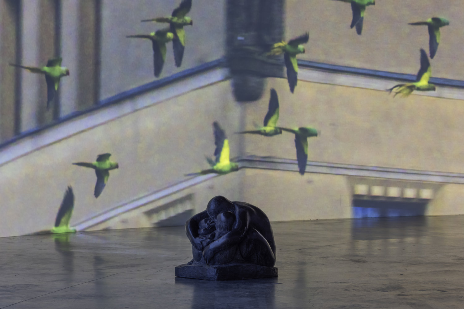 Eine Statue vor einem Film in dem Papageien fliegen
